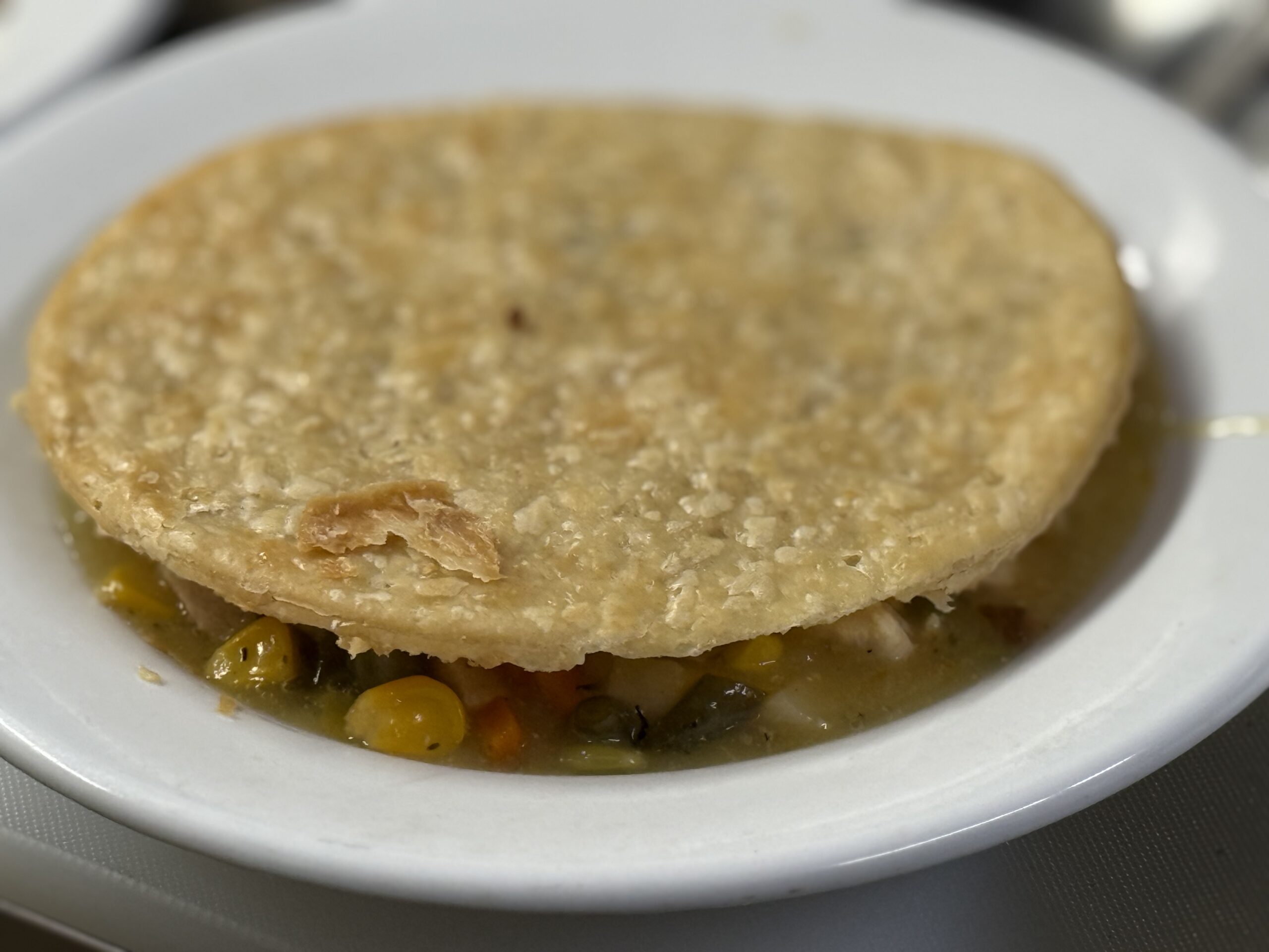 A golden pastry crust over a savory vegetable filling.